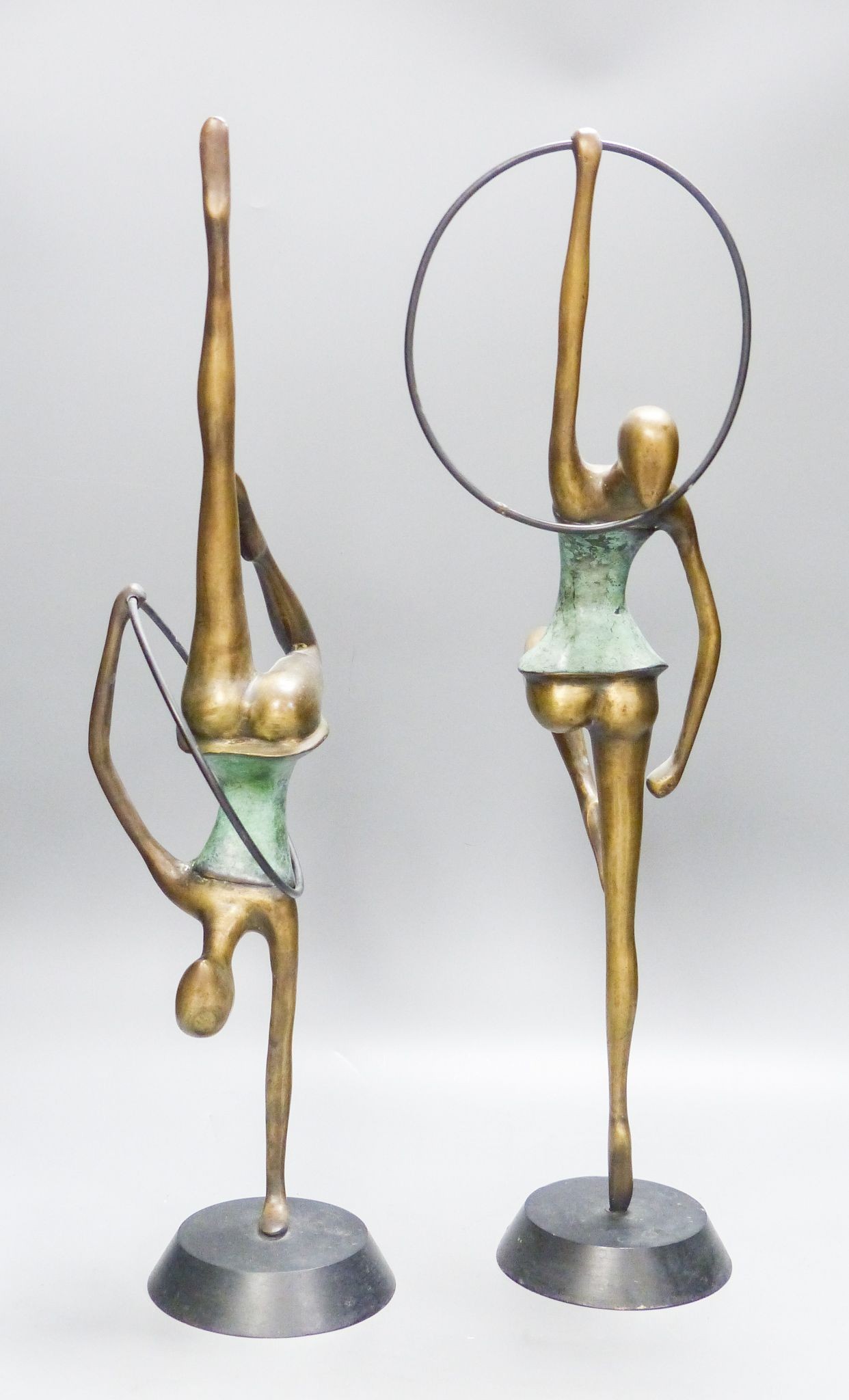 A pair of Hagenauer style bronze figures of hoop dancers, 51.5cm high